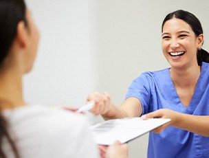 Selbyville patient talking to front desk about financing teeth whitening