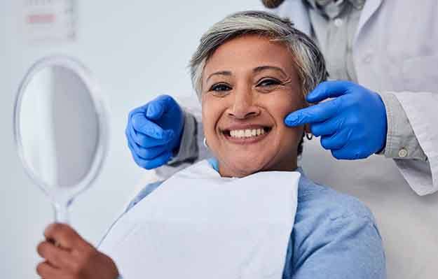 Woman smiling while holding small mirror