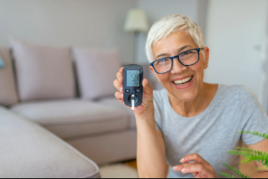 Older woman holding up a blood sugar test